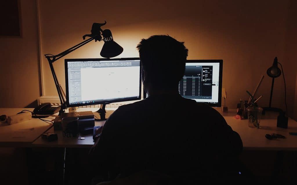 Person using two monitors on their desk