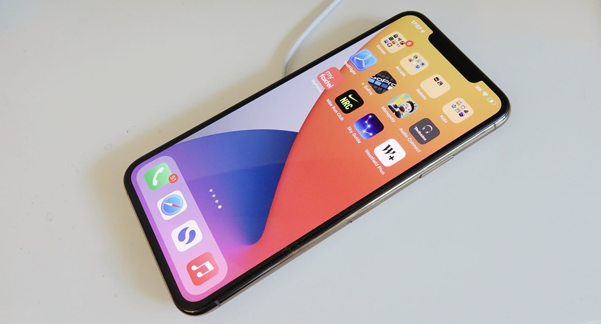 You can charge an iPhone 11 Pro Max on a MagSafe charger, but it won't cling to the back.